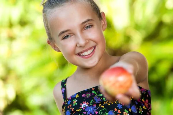 Nettes gesundes Mädchen bietet roten Apfel an. — Stockfoto