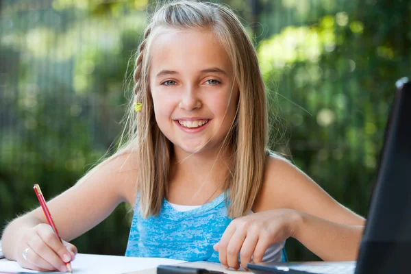 Portret van schattig meisje huiswerk buitenshuis. — Stockfoto