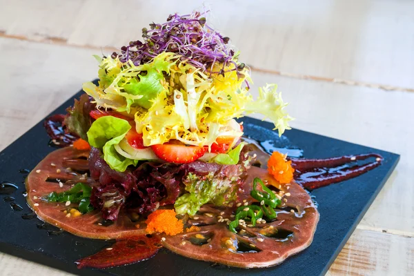 Salat auf schwarzer Fliese serviert. — Stockfoto