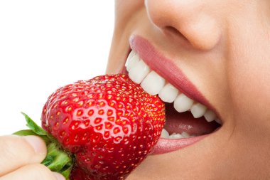 Extreme close up of teeth biting strawberry. clipart