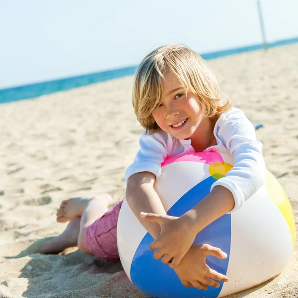 Schattige jongen opleggen strandbal. — Stockfoto