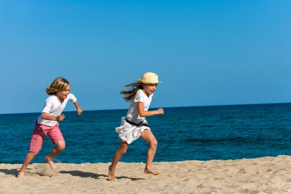 Chłopiec goni dziewczyny na plaży. — Zdjęcie stockowe