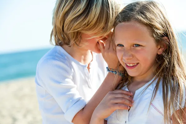 Boy whispering secrets to girl outdoors. — Stock Photo, Image