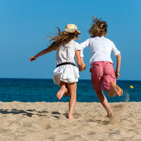 Menino e menina correndo em direção ao mar . — Fotografia de Stock