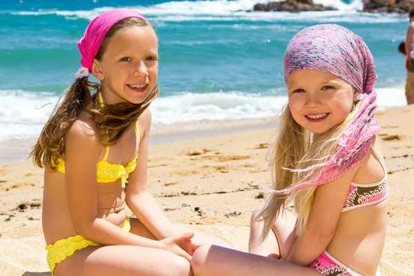 Zwei Freundinnen sitzen am Strand. — Stockfoto