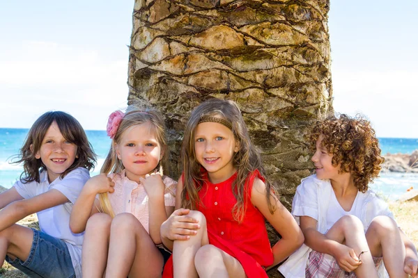 Kinder sitzen neben Palme. — Stockfoto