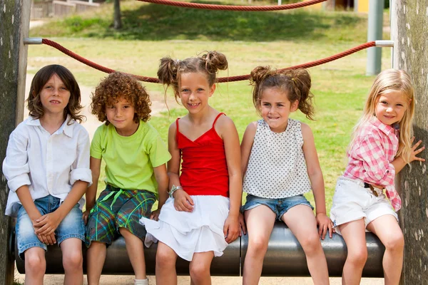 Niños sentados juntos en el parque . — Foto de Stock