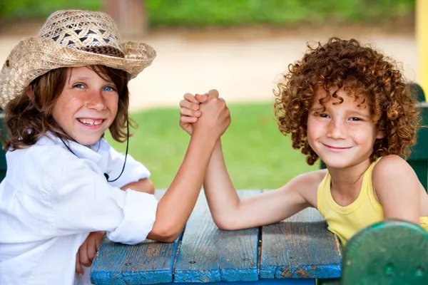 Twee kinderen hebben pols vechten in park. — Stockfoto