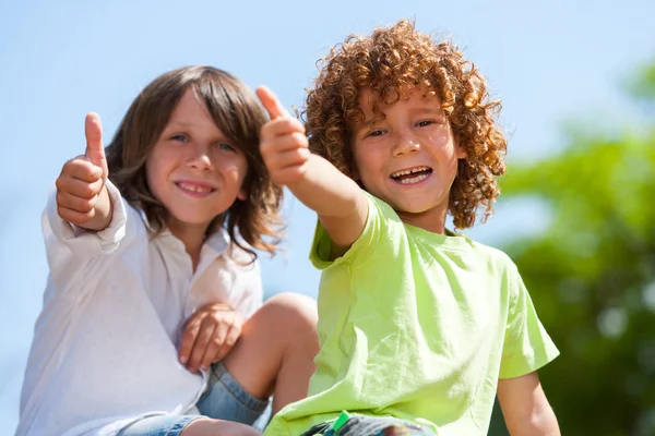 Two cute boys doing thumbs up outdoors. — Stock Photo, Image