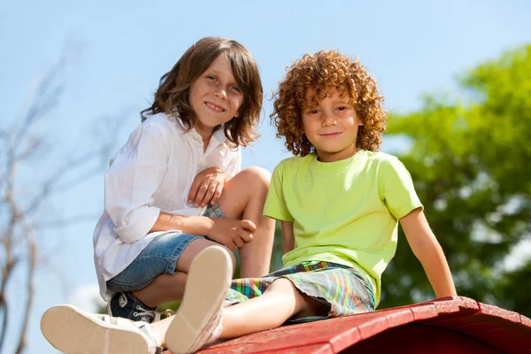 Twee jongens zittend op dak in park. — Stockfoto