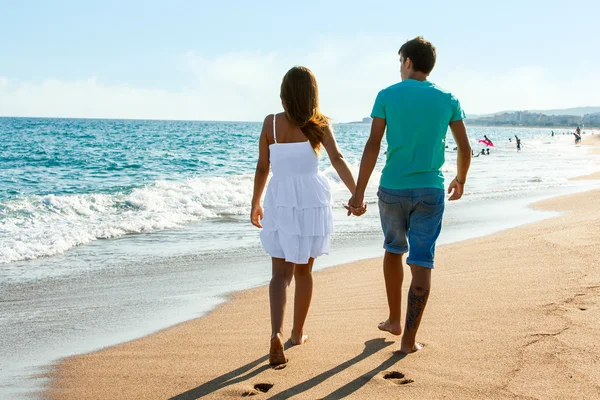 Adolescente pareja caminando lejos en playa . Imagen de stock