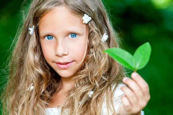 Blue eyed girl holding green leaf. — Stock Photo, Image