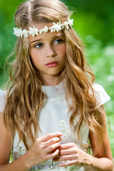 Ragazza carina in abito bianco con fiore in mano . — Foto Stock