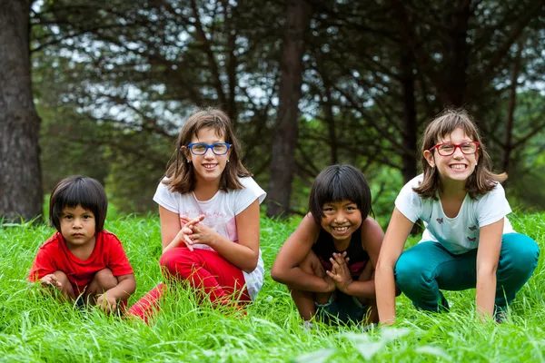 Nette Mädchen sitzen im grünen Grasfeld. — Stockfoto