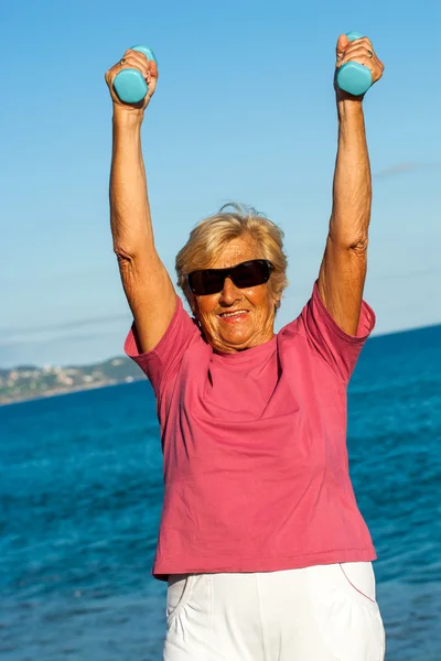Femme âgée soulevant des poids à l'extérieur . — Photo