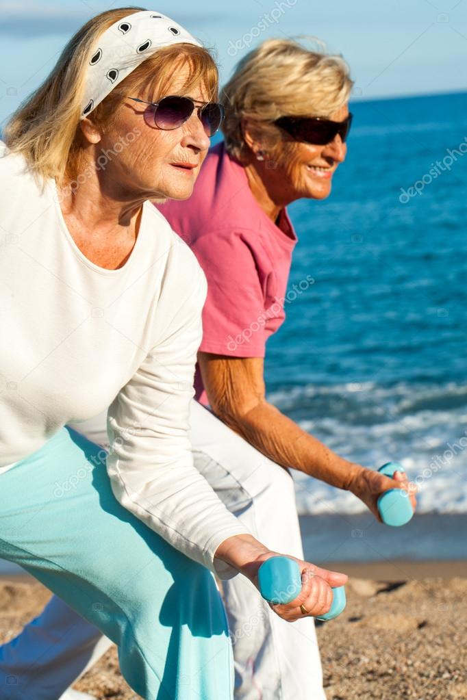 Elderly ladies doing worlout on beach.