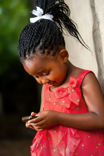 Pigtailed menina africana jogando com telefone inteligente . — Fotografia de Stock