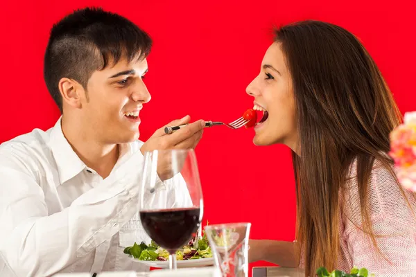 Menino alimentando namorada na mesa de jantar . — Fotografia de Stock