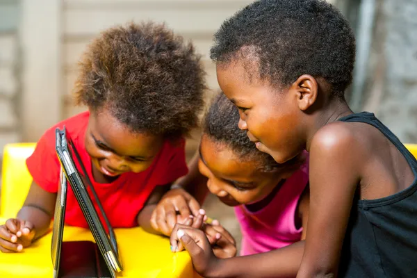 Threesome african kids having fun with tablet. — Stock Photo, Image