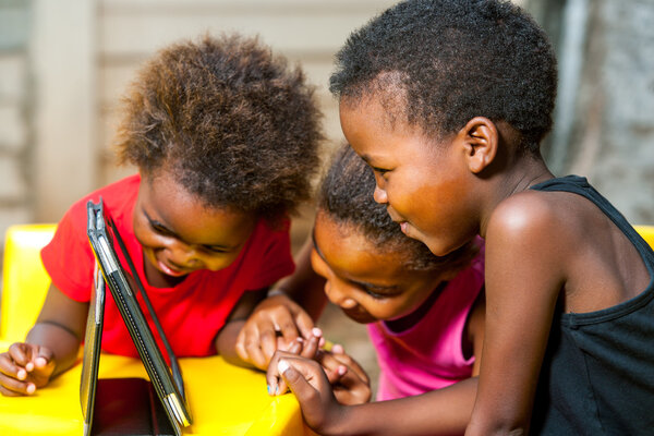 Threesome african kids having fun with tablet.