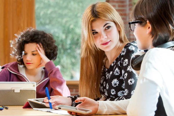 Junge Studentinnen diskutieren über Hausaufgaben. — Stockfoto