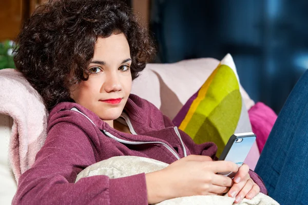 Teen girl on couch with smart phone. — Stock Photo, Image