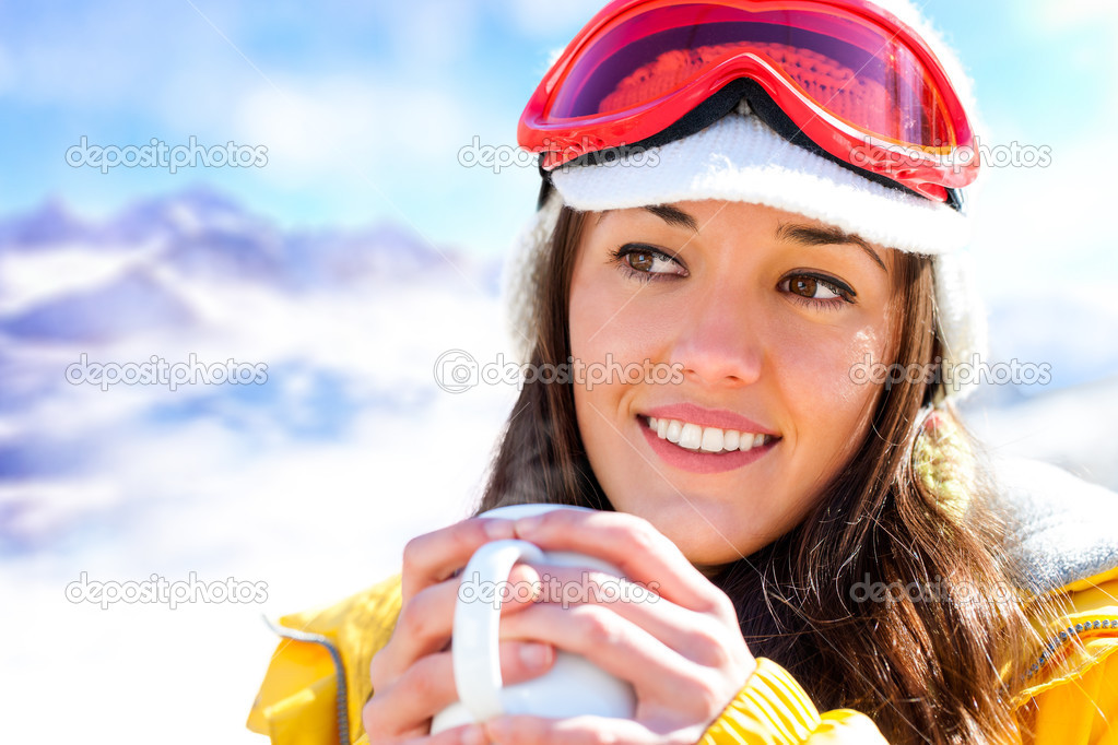 Female skier drinking coffee.