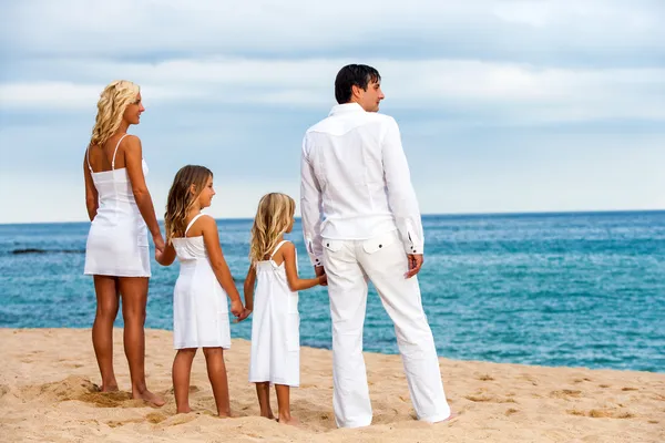 Familjen håller händerna på stranden. — Stockfoto