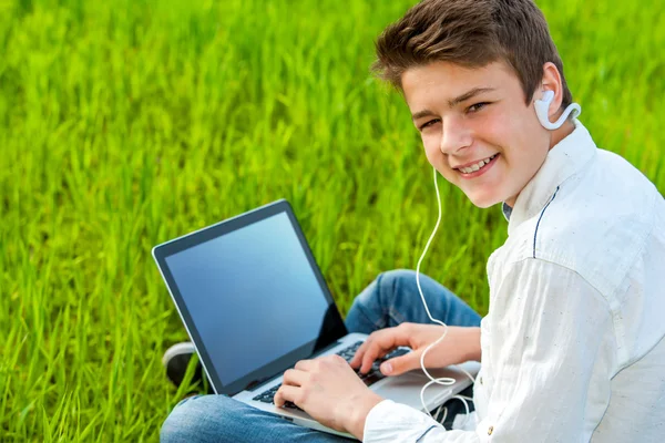 Підліток працює на ноутбуці на відкритому повітрі . — стокове фото