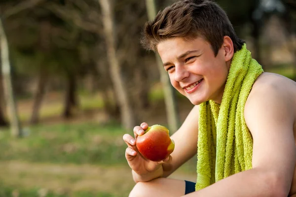 Teen eating apple after ecercise. — Stock Photo, Image