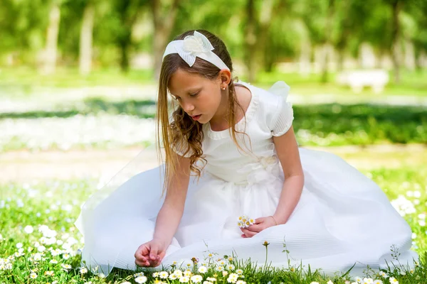 Dolce ragazza in abito bianco raccogliendo fiori . — Foto Stock