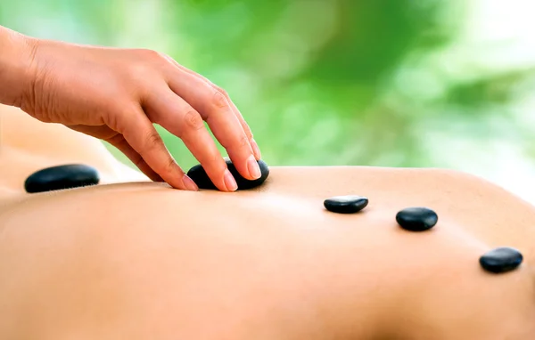 Terapeuta ręki robi masaż gorącymi kamieniami. — Zdjęcie stockowe