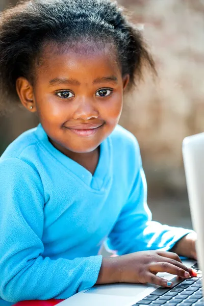 Linda chica africana escribiendo en el ordenador portátil . —  Fotos de Stock