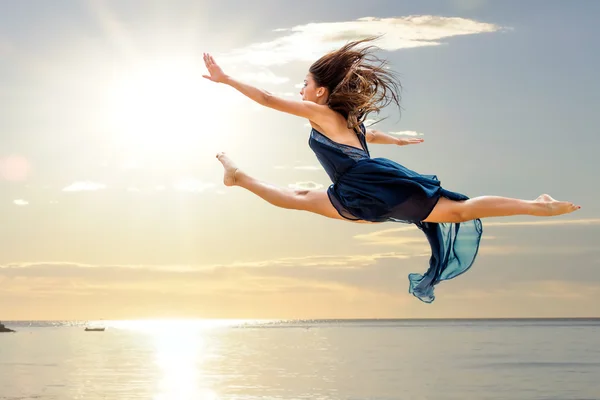 Dívka dělá umělecké skok při západu slunce — Stock fotografie
