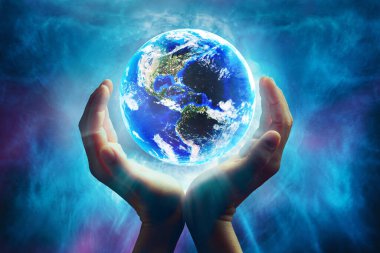 Kavramsal soyut görüntü elleri parlayan mavi ana toprağı tutuyor. Dünya resmi NASA tarafından sağlandı.