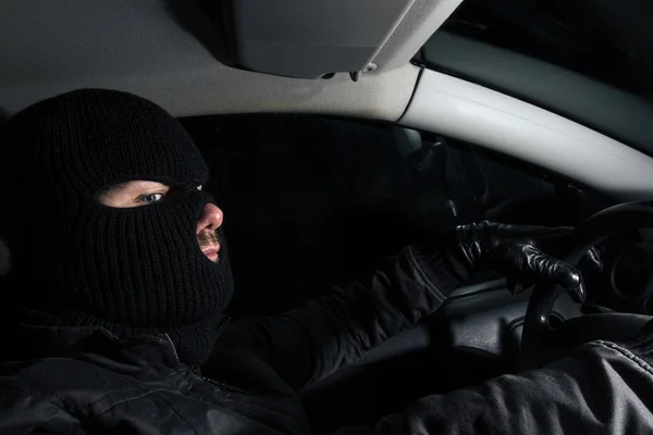 Masked man sitting in a car — Stock Photo, Image