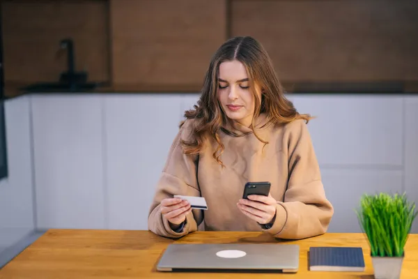 Genç Güzel Bir Kadın Akıllı Telefon Kredi Kartını Kullanarak Evde — Stok fotoğraf