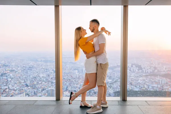 Ρομαντικό Ζευγάρι Αγκαλιές Κοντά Στο Παράθυρο Του Ένα Ψηλό Κτίριο — Φωτογραφία Αρχείου