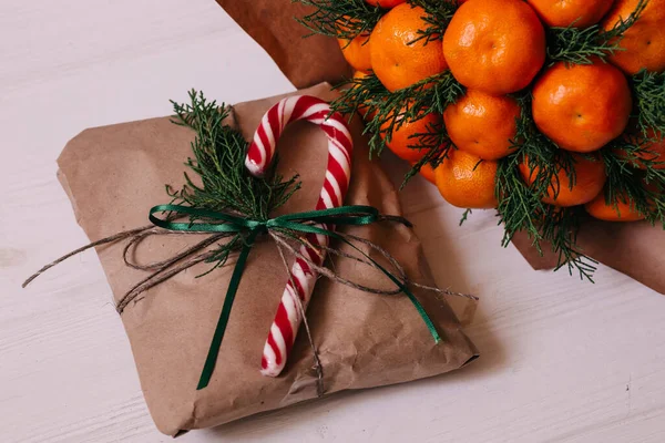 Geschenke Bastelpapier Eingewickelt Mit Fichtenzweigen Und Mandarinenstrauß Verziert — Stockfoto