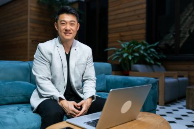 Asyalı adam dizüstü bilgisayar kullanıyor. Öğrenci çalışmaları, online çalışmalar. Yetişkin, profesyonel insanlar. ticari teknolojik cihazlar için konsept