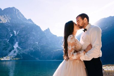 İki sevgili öpüşür. Romantik bir ortam. Dağ nehrinin kıyısında yeni evli bir çift..