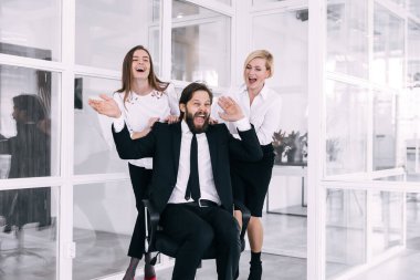 Mutlu iş arkadaşları birlikte eğleniyor, ofis sandalyesinde yuvarlanıyorlar, tatilde eğlenceli bir oyun oynuyorlar, cuma gününü kutluyorlar..