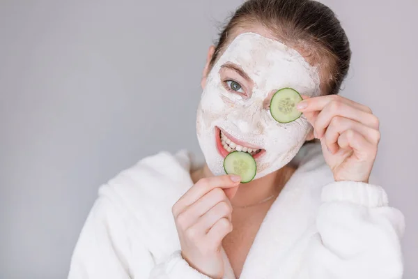 Gadis Tersenyum Dengan Topeng Kosmetik Dan Irisan Mentimun Segar — Stok Foto