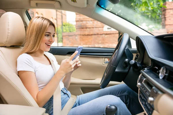 Gadis Tersenyum Membaca Pesan Ponsel Duduk Kursi Pengemudi Dalam Mobil — Stok Foto