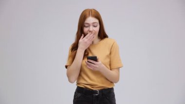 Son derece mutlu, memnun bir kız akıllı telefonunu kullanıyor. Komik kız iyi haberler almış..