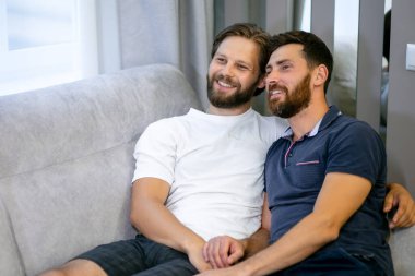 Aynı cinsiyetten bir çifti seviyorlar. Evde TV seyrediyorlar ve birlikte rahatlıyorlar.
