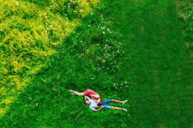Aerial view of a couple in love lying in field. copter.