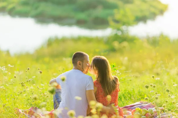 湖に座ってキスしてる男と女 バックビュー — ストック写真