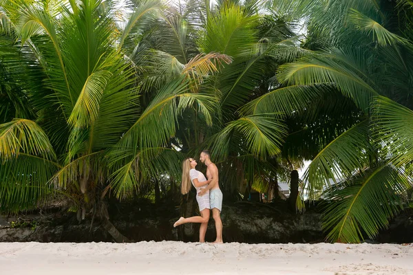 一个有魅力的男人和一个女孩在大自然的背景下的画像 游客在棕榈树附近摆姿势的照片 — 图库照片
