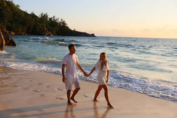 一对快乐的年轻夫妇在马尔代夫岛上的海滩上散步 — 图库照片